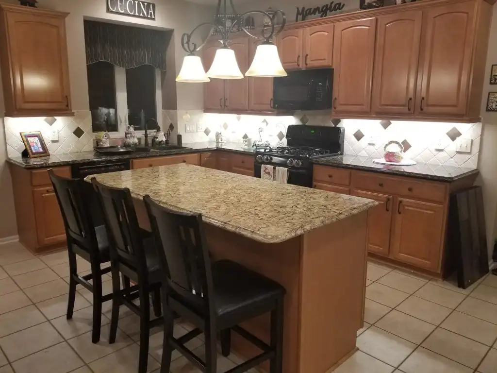 https://columbuscabinetscity.com/wp-content/uploads/2023/03/Kitchen-with-Browns-Cabinets-and-Black-Appliances-in-Columbus-Ohio.webp